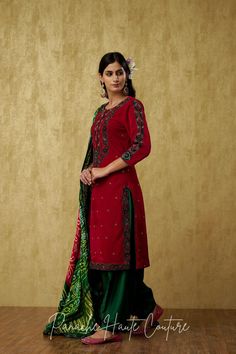 Introducing our Stunning Dark Emerald Green and Red Punjabi Suit Set, a mesmerizing outfit that will leave everyone awestruck. The kameez is made of luxurious red velvet, which gives it a regal and rich look. The dark emerald green embroidery on the kameez adds a touch of elegance and sophistication to the overall design. The salwar is made of plain silk in a green color that complements the kameez beautifully. The green monotone embroidery on the salwar adds a subtle yet stylish touch to the ou Red Bandhani Print Palazzo Set With Traditional Drape, Red Bandhani Print Palazzo Set For Festive Occasions, Festive Red Palazzo Set With Bandhani Print, Elegant Designer Wear Dupatta With Bandhani Print, Red Sharara With Bandhani Print And Straight Kurta, Elegant Bandhani Print Dupatta For Designer Wear, Elegant Red Salwar Kameez For Navratri, Red Unstitched Suit With Mirror Work For Festive Occasions, Designer Red Unstitched Suit With Mirror Work