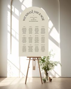 a table plan sitting on top of a easel next to a potted plant