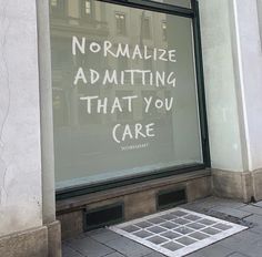 a store window with the words normalize admiting that you care written on it