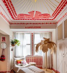 a room decorated in red, white and gold with a palm tree on the floor