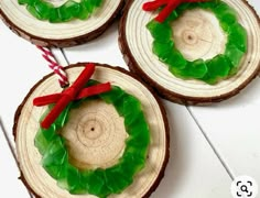 three pieces of wood with green and red decorations on them, tied to twine