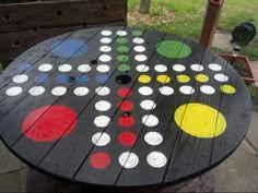 an outdoor table made out of wooden boards with circles painted on the top and bottom