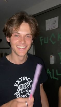 a young man holding a purple object in his hand