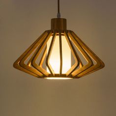 a wooden light hanging from the ceiling in a room with white walls and flooring