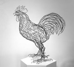 a wire sculpture of a rooster on top of a white pedestal in front of a wall