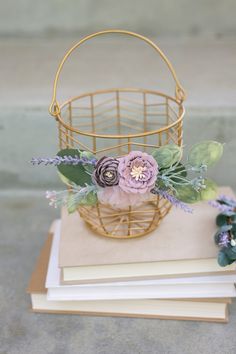 a basket filled with flowers sitting on top of books