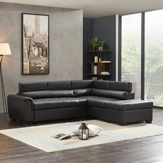 a black leather sectional sofa sitting in a living room next to a lamp and rug