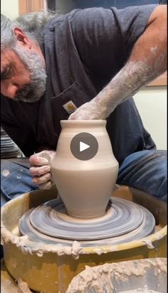 a man is making a vase out of clay