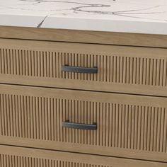 a close up of a wooden dresser with drawers and marble counter top in the background