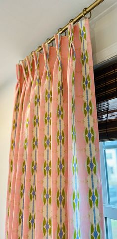 a pink curtain with green and blue designs