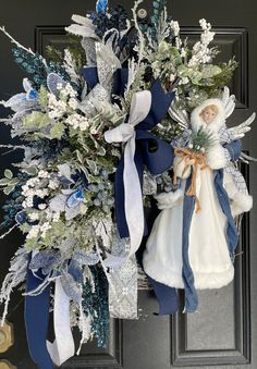 a wreath with an angel and snowflakes hanging from it's front door