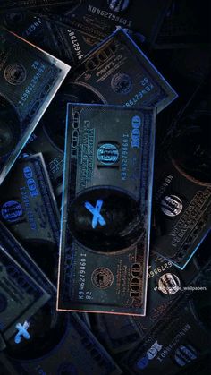 a pile of money with the word x on it in front of some lit up cds