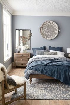 there are two pictures of a bedroom with blue walls and white furniture in the same room