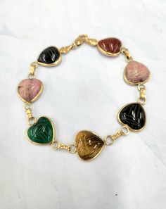 Super Sweet! Multi gemstone carved scarab hearts all linked on a 14k bracelet. This bracelet features onyx, rose quartz, tiger's eye,  carnelian and chrysoprase gemstones  All bezel set in yellow gold 7 inch length 10.50 grams total weight Rib Ring, Baguette Diamond Band, Flower Diamond Ring, Egyptian Scarab, Heart Gemstone, Diamond Rings Bands, Tiger's Eye, Baguette Diamond, Super Sweet