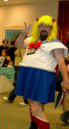 a man dressed up as a sailor in a room full of people