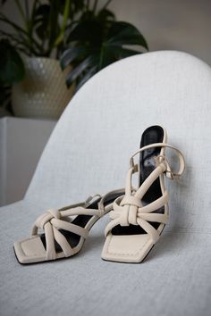 Strap yourself in: our Amara Sandals are about to take your style to new heights. Our open square-toe design is set on a spool heel (suitable for all-day wear) with padded straps that come together in a center knot. From soft 100% Italian nappa leather, Amara is an arresting silhouette that pairs beautifully with casual or cocktail looks. [SPLIT] Yada wears Amara in cream, and in black. Astrid wears sand, and hot pink. Heel height is approximately 3" (8 cm). Sold in US sizes, though please note Elegant Square Toe Sandals With Straps, Formal Square Toe Lace-up Sandals For Summer, Formal Summer Lace-up Sandals With Square Toe, Formal Lace-up Sandals With Square Toe For Summer, Spring Strappy Heels With Square Toe, Spring Square Toe Sandals With Straps, Square Toe Sandals With Straps For Spring, Summer Lace-up Sandals With Square Toe, Spring Slingback Sandals With Wrapped Heel And Square Toe