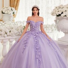 Our Lavender Quinceanera Ball Gown Is A Dreamy Masterpiece For A Magical Celebration! Off-The-Shoulder Sleeves And Lace-Up Corset Back Add Romance, While Layers Of Tulle Create Fairytale Silhouette. The Gown Is Adorned With Three-Dimensional Floral Appliqu, Giving It A Garden-Like Feel. Fabric: Tulle Length: Long Neckline: Off The Shoulder Silhouette: Ball Gown Sleeve: Sleeveless Back: Lace Up Back Skirt: Layered Embellishments: Floral Applique Occasion: Romantic Date/Evening/Dinner, Wedding/Bri Quinceanera Dresses Lilac, Purple Wedding Dress The Bride, Purple 15 Dresses Quinceanera, Ball Gowns Purple, Fairytale Silhouette, Rapunzel Quinceanera, Big Princess Wedding Dresses, Light Purple Quinceanera Dresses, Quinceanera Dresses Lavender