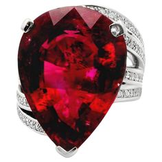 A large and impressive pear-shape rubellite tourmaline weighing in at 18.65 carats. It has a rich and vibrant red color that glows it in light and is set in the center of a chic platinum ring with waves of movement. There are 0.53 carats of round brilliant-cut diamonds set over the waves of platinum running up and down the sides of the ring. Hand-fabricated in platinum, this lovely rubellite ring is ready to be worn and loved. Ring Size 7.5 Weight: 24.6 grams Rubellite Ring, Diamond Pendants Designs, Rubellite Tourmaline, Ring Hand, Platinum Ring, Pendant Design, Ring Size 7, Round Brilliant Cut Diamond, Cocktail Ring