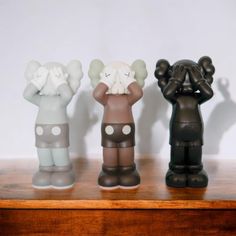 three small figurines are sitting on a table