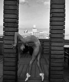 a woman in a bathing suit leaning on some wooden blocks