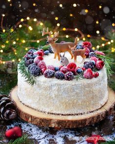 a christmas cake with berries, pine cones and reindeer figurines on it in russian