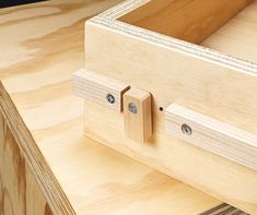 a wooden drawer with two screws on the top and one in the bottom part