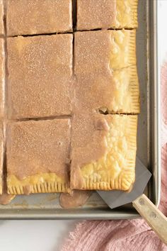 an uncooked pastry sitting on top of a baking pan next to a spatula