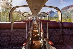 the inside of an empty train car with mountains in the background