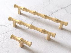 three golden handles on a white wall