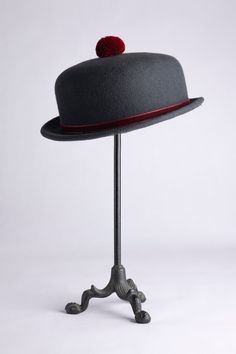 "A vintage inspired hat, this cute short-brimmed piece comes decorated with a velvet ribbon to match a cotton pompom sitting on top. Made out of wool felt, this hat has been stiffened enough so it can never be crushed! Choose between our two neutral options: a dark grey hat with burgundy velvet and pompom, or a dark brown piece with caramel ribbon and pompom. Brim size is 1\". Crown is 2\"1/2 high.  Can be adjusted to your head size (up to 23\" 1/2)" Winter Mini Hats With Short Brim In Felt, Curved Brim Felt Hat For Derby And Winter, Winter Derby Fedora Hat, Winter Derby Felt Hat With Flat Brim, Adjustable Felt Fedora Mini Hat, Winter Mini Hats With Short Brim, Winter Mini Felt Hats With Short Brim, Winter Derby Felt Hat With Curved Brim, Fur Felt Boater Hat For Kentucky Derby