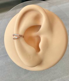 a fake ear is sitting on top of a glass plate with a ring in it