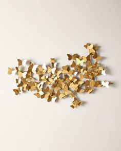 gold and white butterflies are scattered on a white surface, as if they were cut from paper