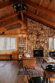 a living room filled with furniture and a fire place next to a stone covered wall