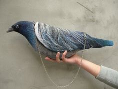 a person holding a bird with chains on it's neck and chain around its wrist