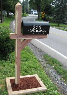 a mailbox stands in the grass next to a road