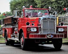 a red fire truck driving down a street