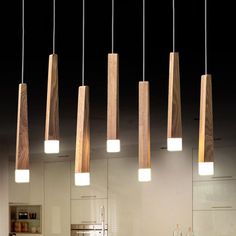 several wooden lights hanging from the ceiling in a kitchen