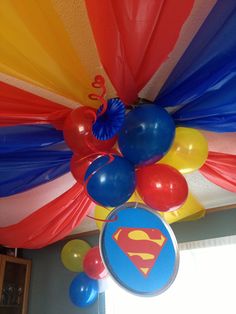 the ceiling is decorated with balloons and streamers for a superman themed birthday party at home