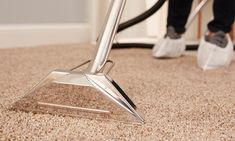 a person using a vacuum to clean carpet