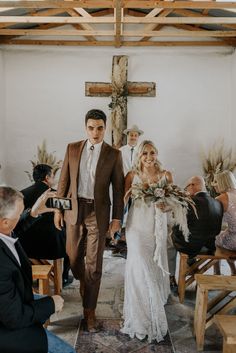 a bride and groom walking down the aisle