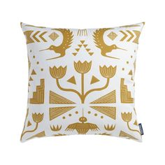 a white and gold pillow with an abstract design on the front, featuring birds and flowers