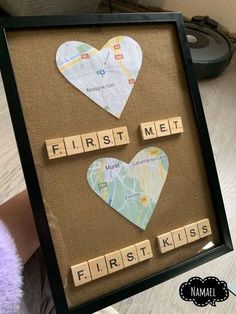 scrabbled paper hearts are displayed in a shadow frame with the words first me and first kiss