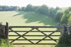 an open gate leading to a lush green field