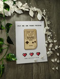 a piece of paper with an old gameboy on it and some flowers around it