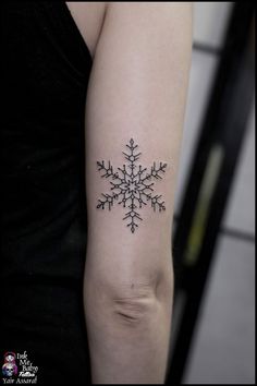 a snowflake tattoo on the arm