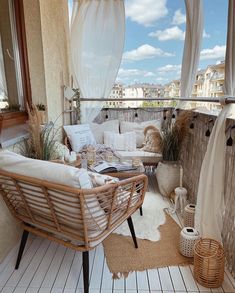 a balcony with wicker furniture and white drapes on the window sill,