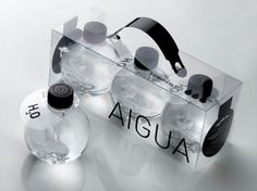 two clear bottles sitting next to each other on top of a white surface with black lettering