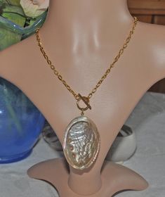 Dive into elegance with our beautiful necklace, featuring an 18K gold-plated stainless steel chain and a stunning Pinto abalone shell as the centerpiece. This unique piece measures approximately 42 cm (17") and secures with a stylish 18K gold-plated toggle clasp. Perfectly blending classic and trendy, the necklace captures an oceanic theme, making it a must-have for mermaid-inspired jewelry lovers. Plus, it's reversible, offering versatile styling options. Whether you're dressing up for a specia Elegant Shell Necklace With Lobster Clasp As Gift, Elegant Pendant Shell Necklace With Lobster Clasp, Gold Toggle Necklace With Pearl Pendant As Gift, Gold Pearl Necklace With Large Pendant, Elegant Gold Shell Necklace With Round Pendant, Handmade Gold Long Shell Necklace, Handmade Gold Toggle Necklace Gift, Handmade Gold Toggle Necklace As Gift, Elegant Gold Round Shell Necklace