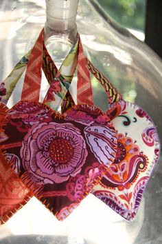 an origami heart hanging from a glass bottle