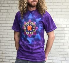 a man standing in front of a brick wall wearing a t - shirt with an image of a flower on it